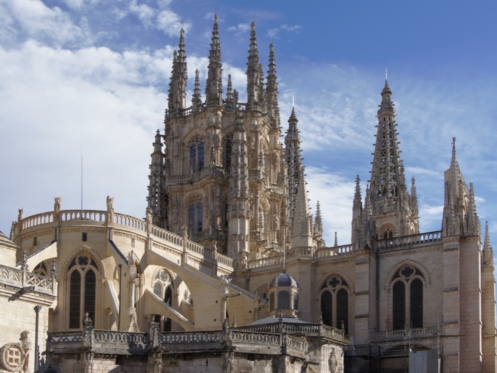 The Gothic spires of Burgos Cathedral against a blue sky