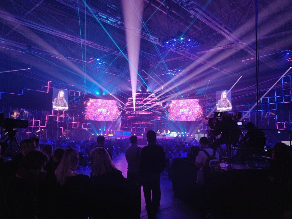 A stage at Slush 2019 in Helsinki in purple light, with the audience in silhouette