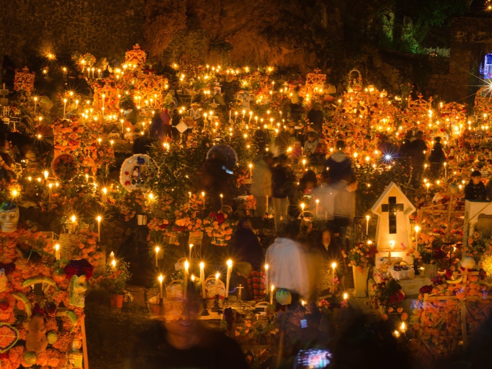 Candles and flowers covering the graves of the cemetery on Janitzio island at night