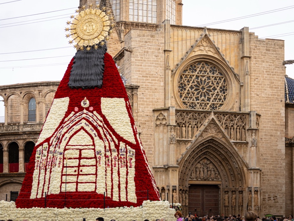 The giant figure of the Virgin covered in red and white flowers in front of Valencia Cathedral