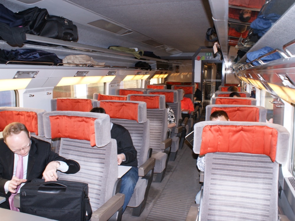 A passenger with a laptop bag at his seat in a first-class Eurostar coach