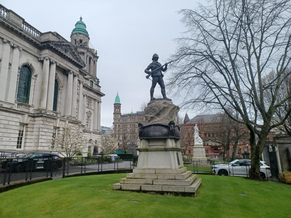 Belfast City Hall and its gardens under a grey sky