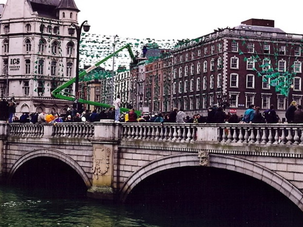 O'Connell Bridge in Dublin hung with green St Patrick's Day bunting, people lining the parapet