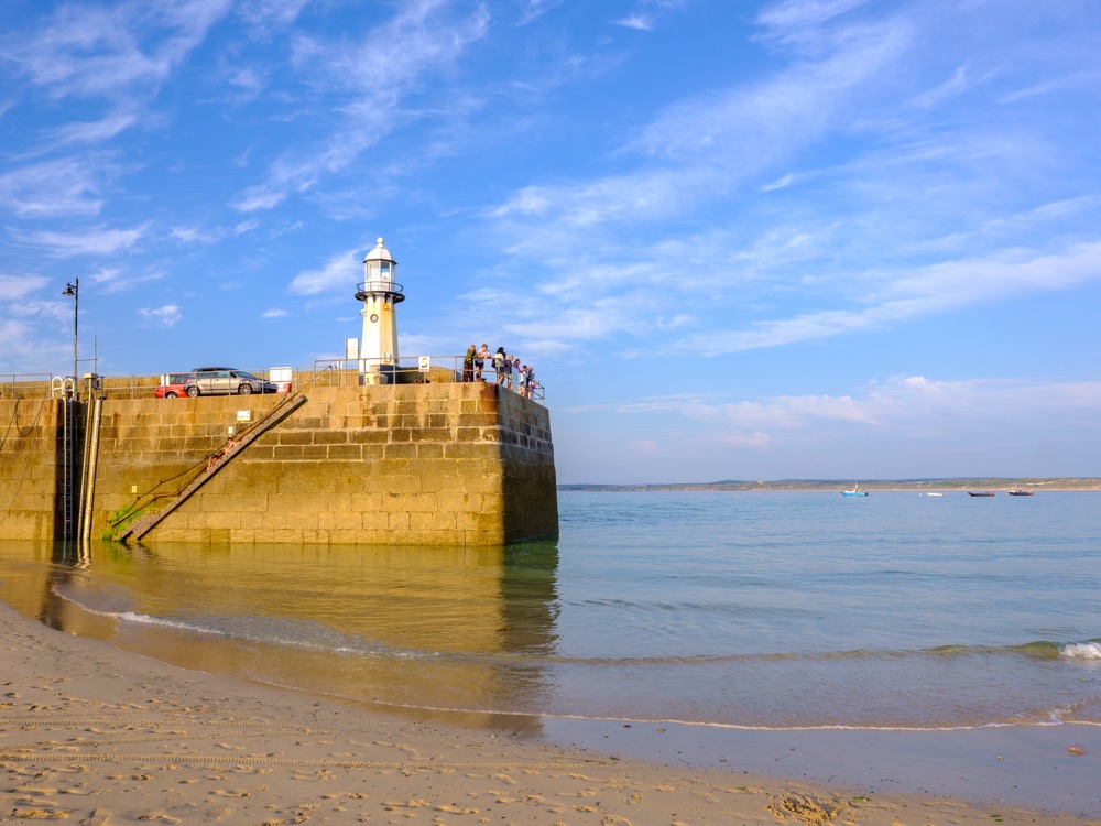 The harbour wall and lighthouse at St Ives in Cornwall at low tide