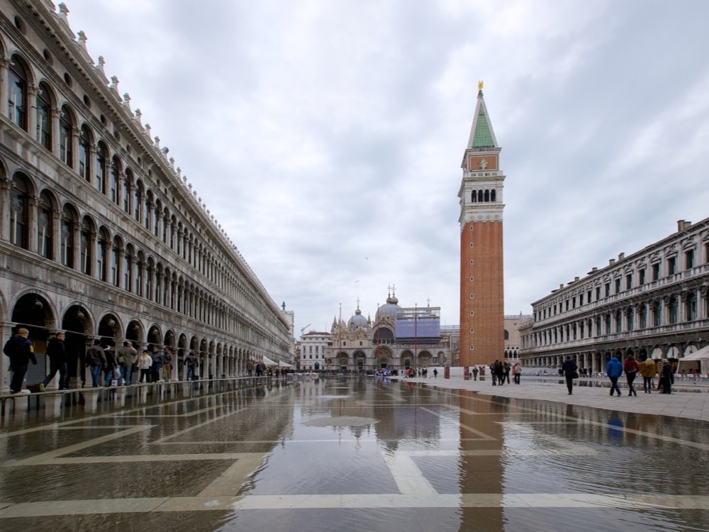 Water covering Piazza San Marco at high tide, with the campanile and the basilica behind