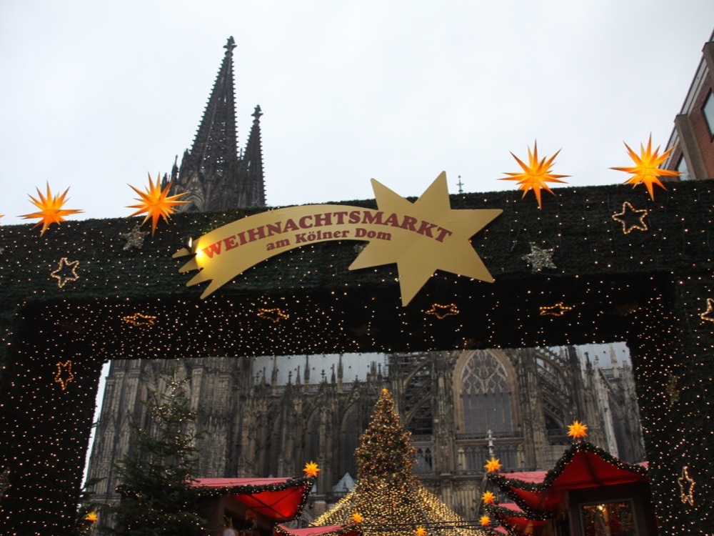 The entrance to the Christmas market below Cologne cathedral, with the cathedral's spires behind