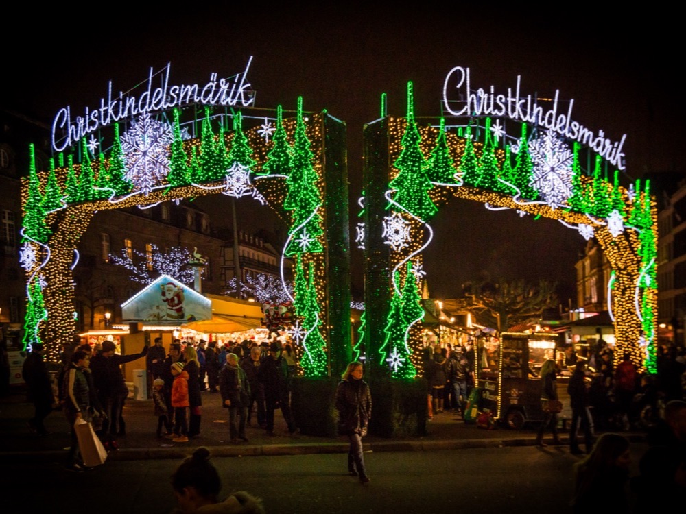 The illuminated Christkindelsmärik entrance arch at the Strasbourg Christmas market at night